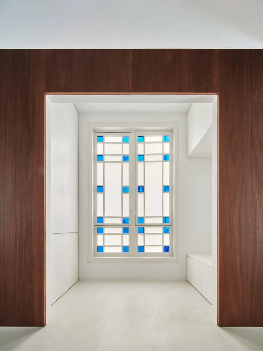 Светлый интерьер квартиры с акцентной стеной из орехового дерева — проект студии Raúl Sánchez Architects