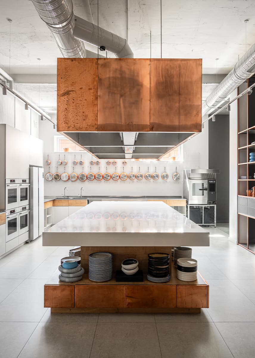Акцентные медные панели и светильник из сетки в интерьере кулинарной студии — проект Алины Воробьевой