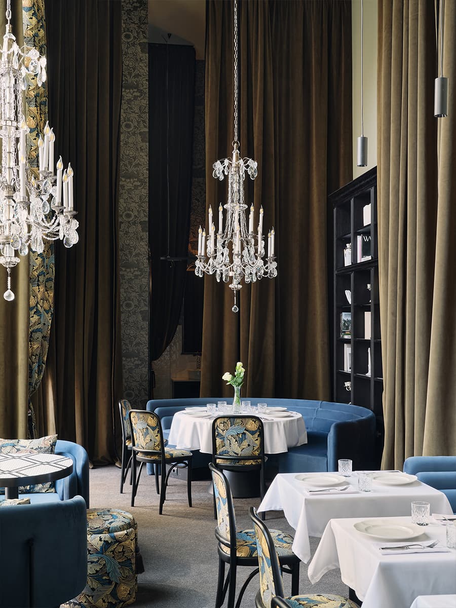 Многоярусные люстры и изящные книжные шкафы в интерьере ресторана — проект Алины Цауня